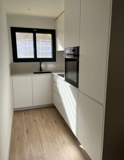 Cocina moderna con estufa y nevera en la Casa Santísima Trinidad del Monte 12 en Sarrià, Barcelona