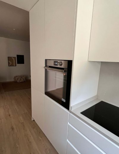 Cocina moderna con estufa y nevera en la Casa Santísima Trinidad del Monte 12 en Sarrià, Barcelona