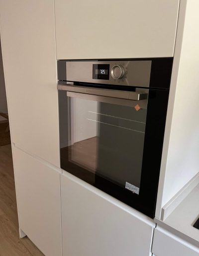 Cocina moderna con estufa y nevera en la Casa Santísima Trinidad del Monte 12 en Sarrià, Barcelona